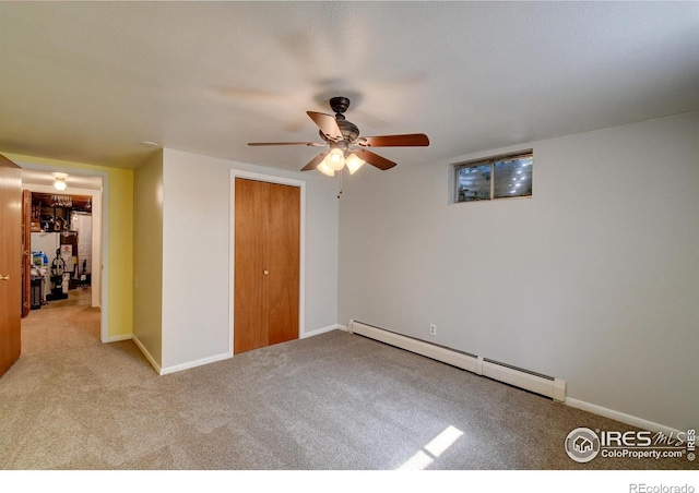 unfurnished bedroom featuring light carpet, a closet, a baseboard heating unit, and ceiling fan