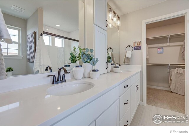 bathroom with tile flooring, oversized vanity, and double sink