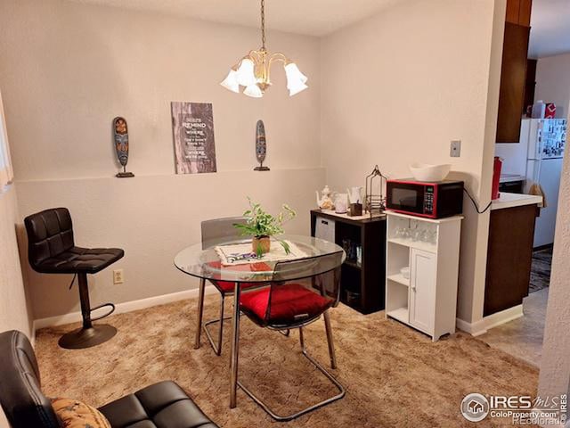 dining area featuring light carpet and an inviting chandelier