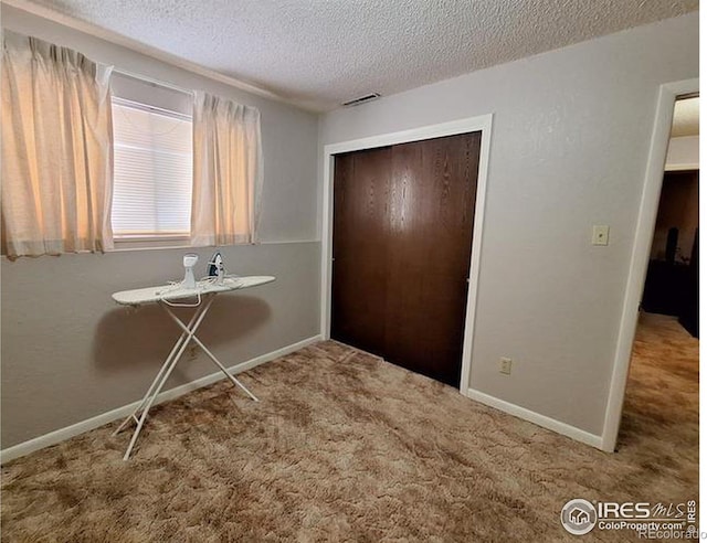 foyer with carpet flooring and a textured ceiling