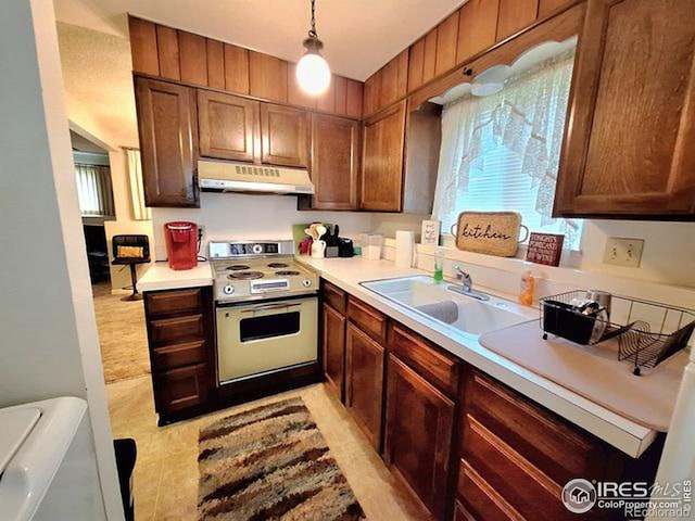 kitchen featuring white electric stove, hanging light fixtures, and sink