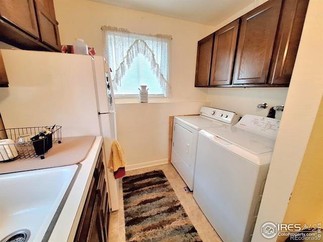 laundry area featuring light tile patterned floors, sink, and washing machine and clothes dryer