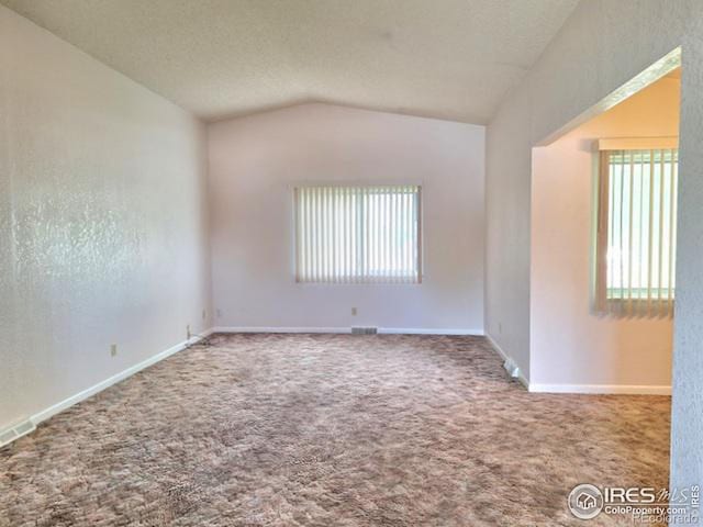 empty room featuring carpet floors and vaulted ceiling