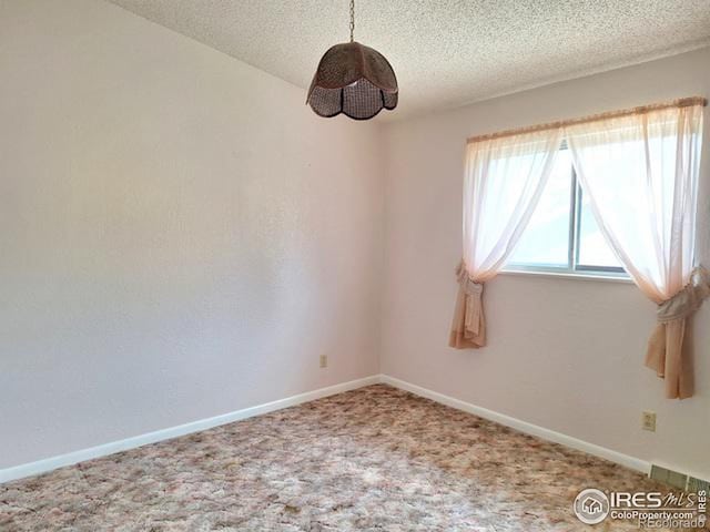 unfurnished room featuring carpet floors and a textured ceiling