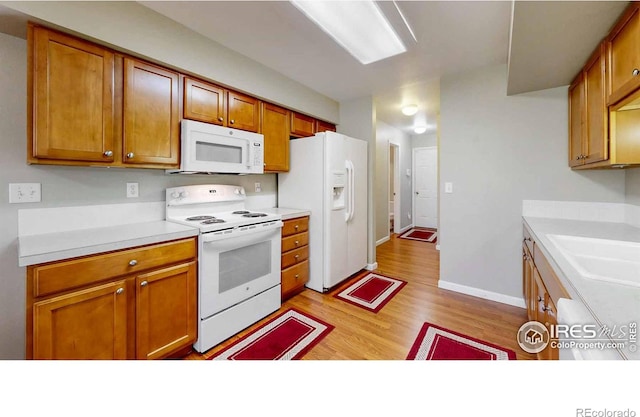 kitchen featuring light hardwood / wood-style flooring, sink, and white appliances