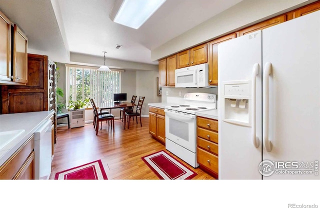 kitchen with light hardwood / wood-style floors, pendant lighting, and white appliances