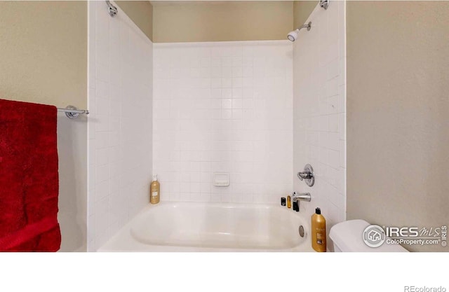 bathroom featuring toilet and tiled shower / bath combo