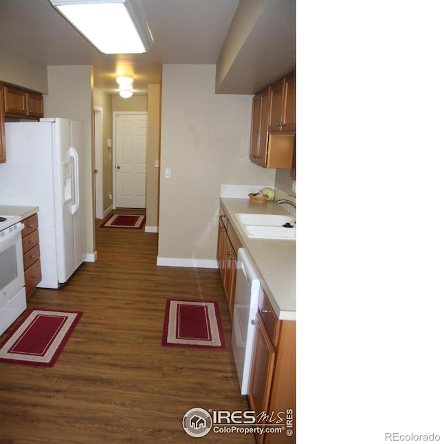 kitchen with dark wood-type flooring, sink, and white appliances