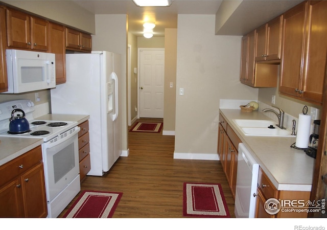 kitchen featuring white appliances, sink, and dark hardwood / wood-style floors