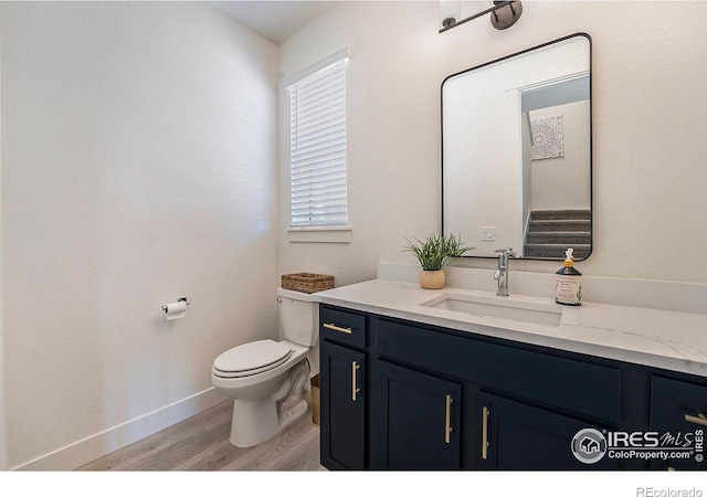 bathroom with hardwood / wood-style floors, vanity, and toilet