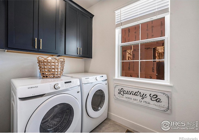 washroom with cabinets and washing machine and clothes dryer