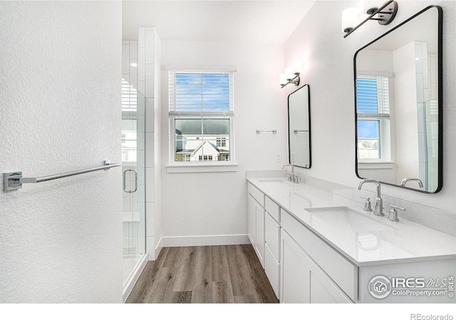 bathroom with vanity, a healthy amount of sunlight, walk in shower, and hardwood / wood-style floors