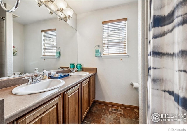 bathroom with a wealth of natural light, vanity, and an enclosed shower