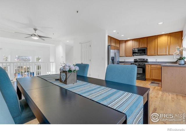 dining space with ceiling fan and light hardwood / wood-style flooring