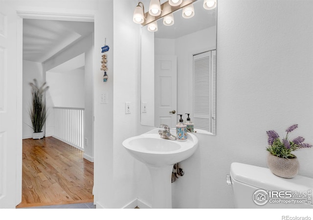 bathroom with toilet and wood-type flooring