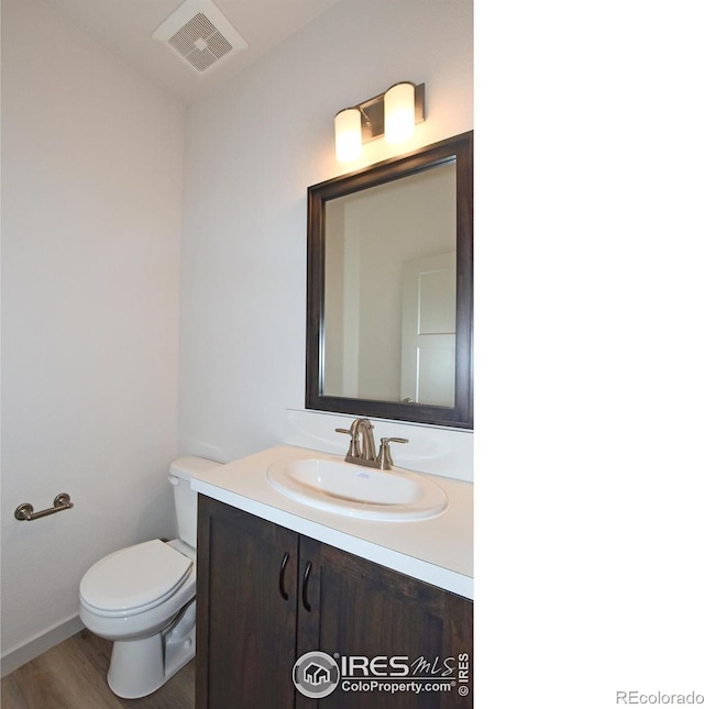 bathroom with vanity, hardwood / wood-style floors, and toilet