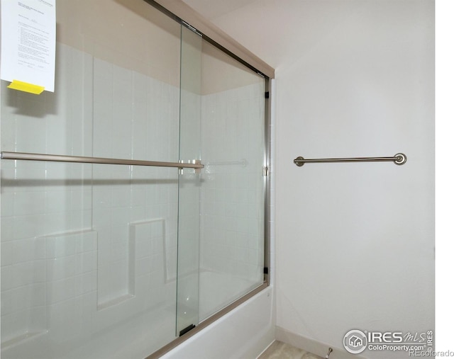 bathroom with shower / bath combination with glass door