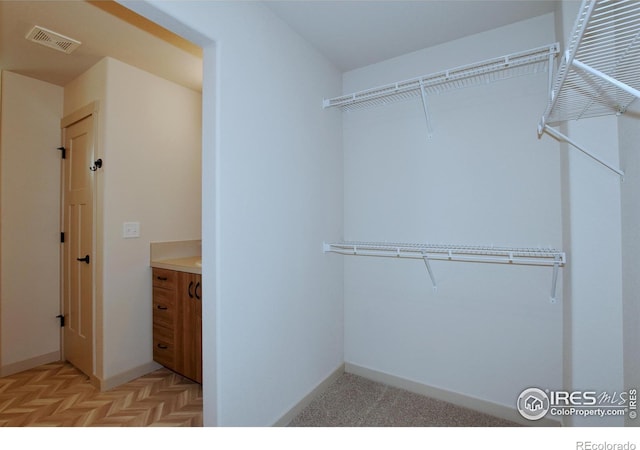 spacious closet featuring light parquet flooring