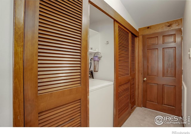 washroom featuring washer / clothes dryer and light colored carpet