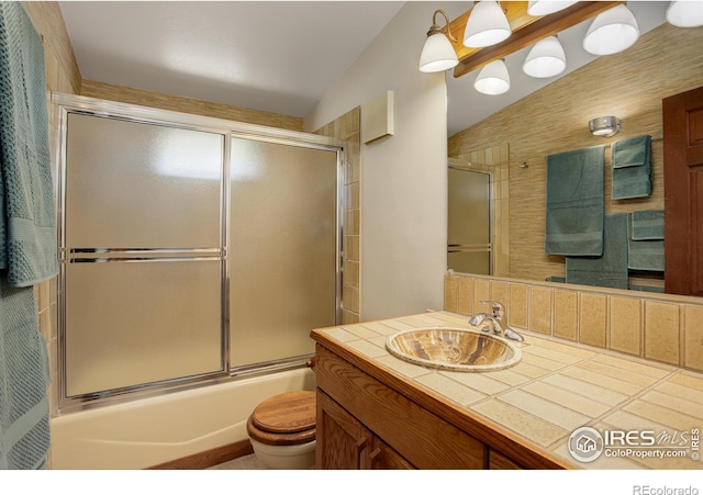 full bathroom featuring toilet, lofted ceiling, shower / bath combination with glass door, and vanity