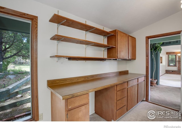 kitchen featuring vaulted ceiling and light colored carpet