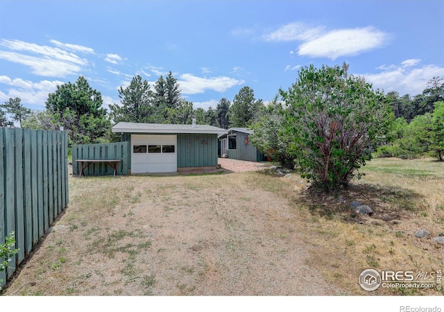 view of yard featuring a garage and an outdoor structure