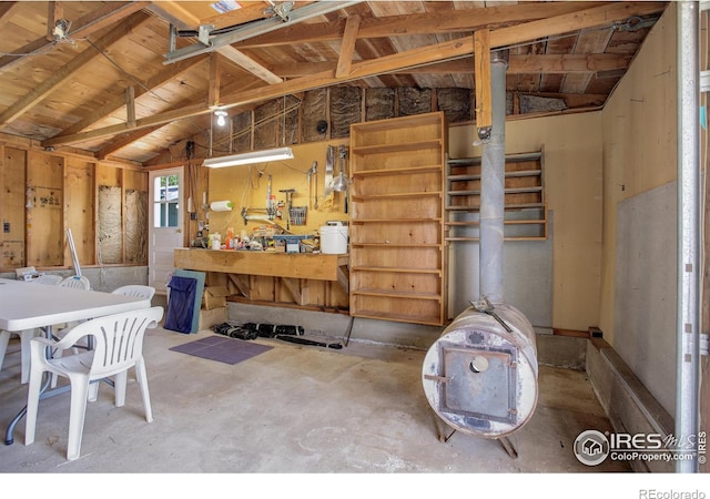 interior space with vaulted ceiling, a workshop area, and concrete floors