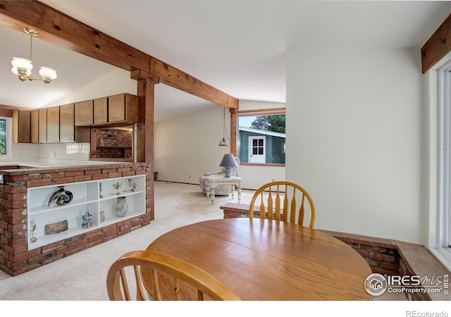 carpeted dining space with a chandelier and lofted ceiling with beams