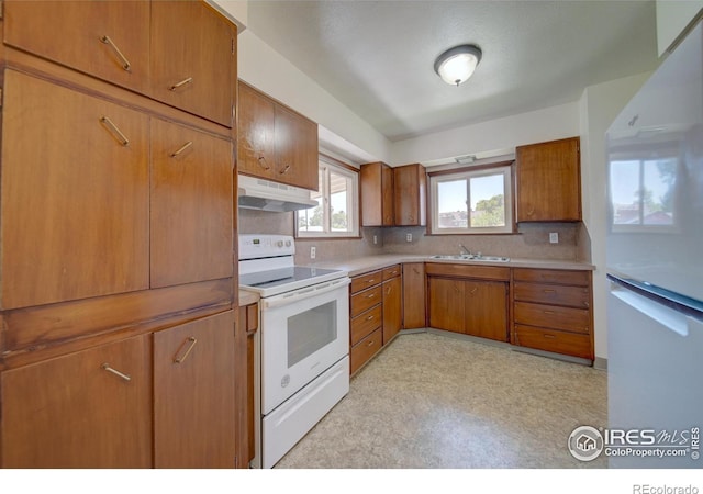 kitchen featuring tasteful backsplash, white range with electric cooktop, and sink