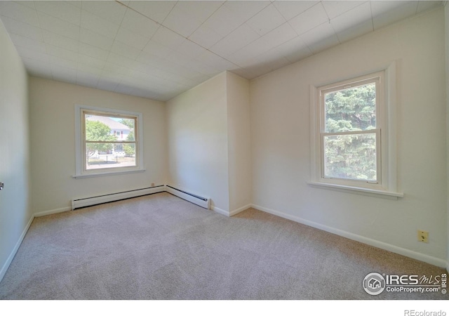 carpeted empty room featuring baseboard heating