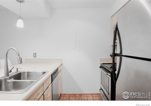 kitchen with decorative light fixtures, light tile patterned flooring, sink, and appliances with stainless steel finishes