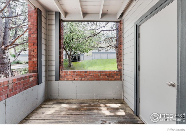 unfurnished sunroom with beam ceiling