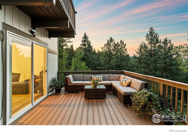 deck at dusk featuring an outdoor hangout area