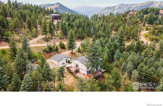 drone / aerial view with a mountain view and a view of trees