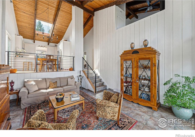 living area featuring high vaulted ceiling, a skylight, wood ceiling, stairs, and beam ceiling