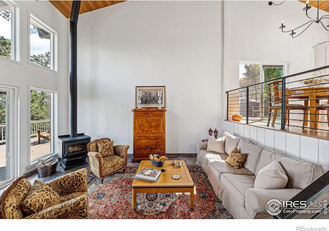 living area featuring a wood stove, wooden ceiling, a high ceiling, and stairs