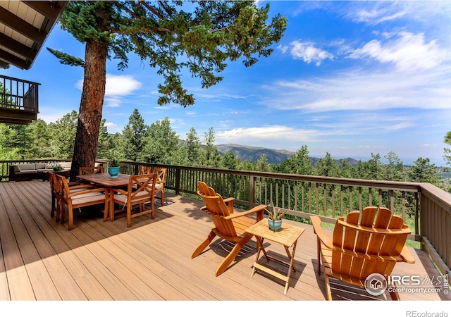 wooden terrace featuring outdoor dining area and a mountain view