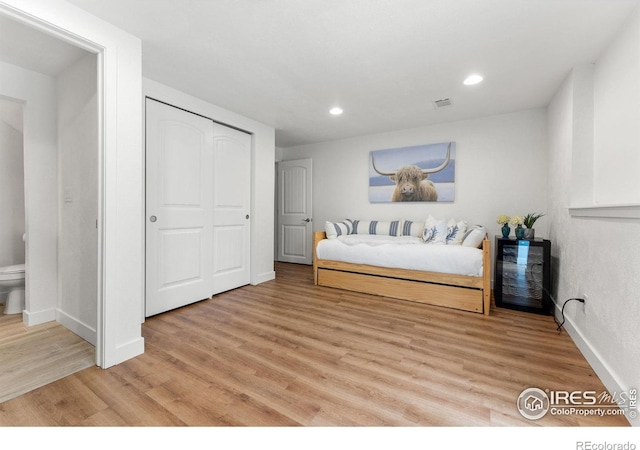 bedroom with a closet and light hardwood / wood-style floors