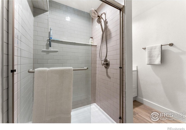 bathroom featuring a stall shower, wood finished floors, and baseboards