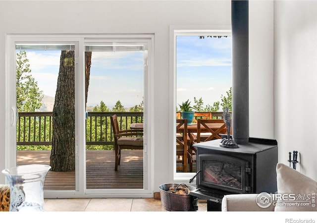 doorway to outside with light tile patterned floors and a wood stove