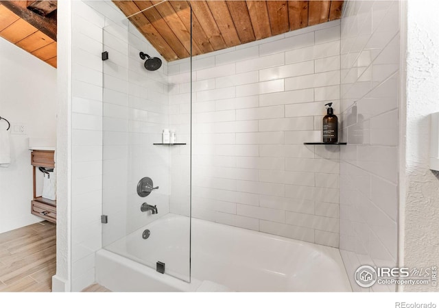 bathroom featuring tiled shower / bath combo, hardwood / wood-style floors, vaulted ceiling, and wooden ceiling