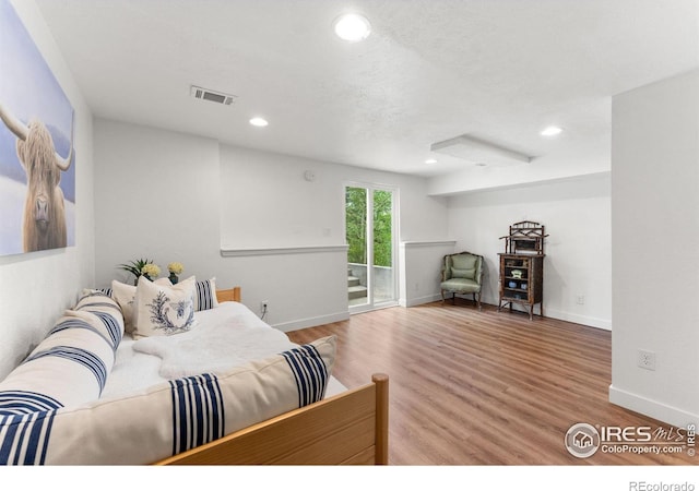 bedroom with recessed lighting, visible vents, wood finished floors, access to outside, and baseboards