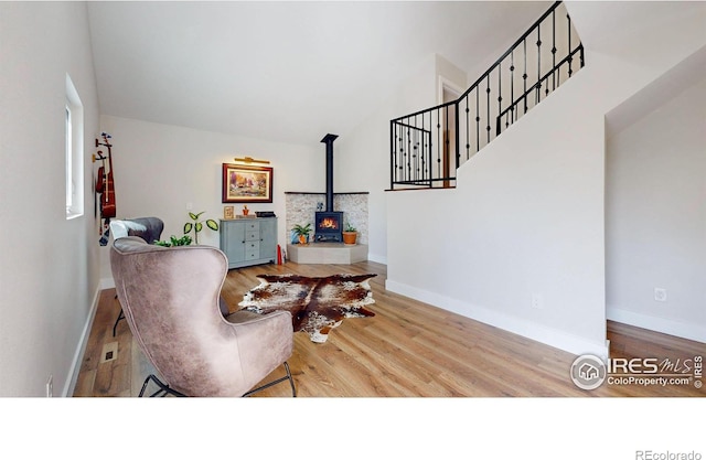 living area featuring a wood stove, hardwood / wood-style floors, and lofted ceiling