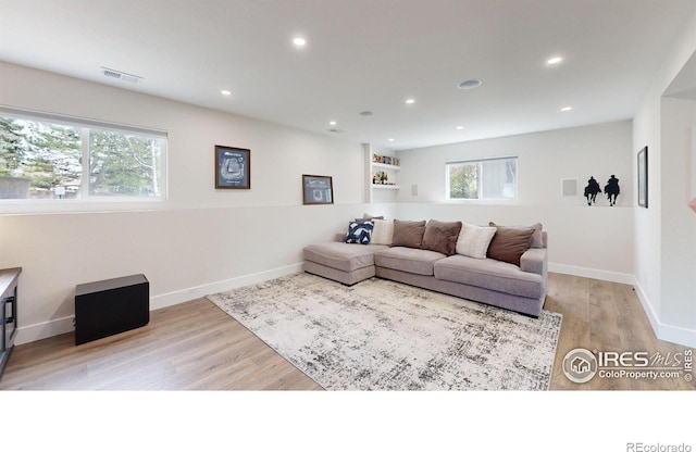 living room featuring a wealth of natural light and light hardwood / wood-style flooring