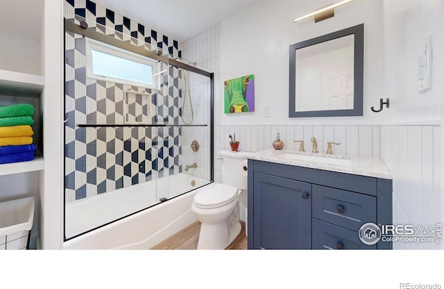 full bathroom featuring hardwood / wood-style floors, vanity, toilet, and enclosed tub / shower combo