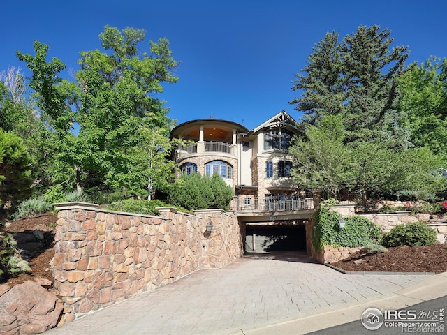 view of front facade with a garage and a balcony