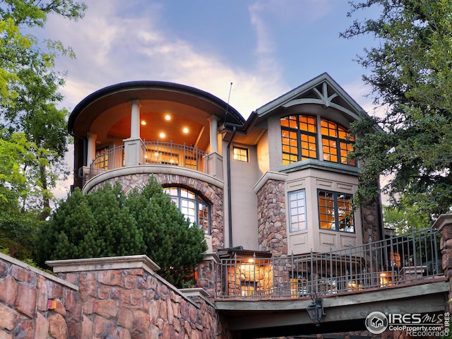 back house at dusk with a balcony