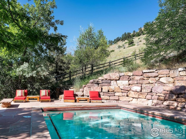 view of swimming pool featuring a mountain view and a patio
