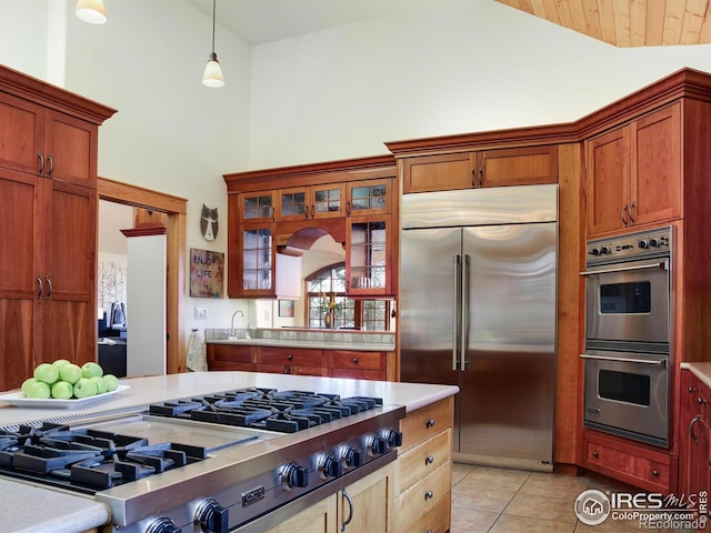 kitchen with hanging light fixtures, light tile patterned floors, and stainless steel appliances