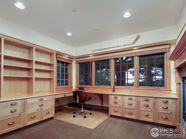 unfurnished office with built in desk and dark carpet